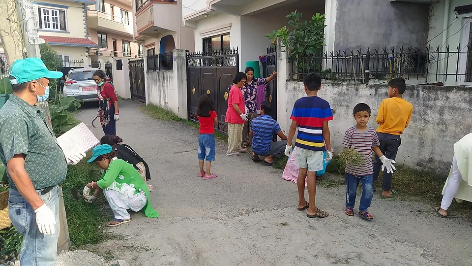 Neighbours of all ages weeding and cleaning their lane with NEPCEMAC staff