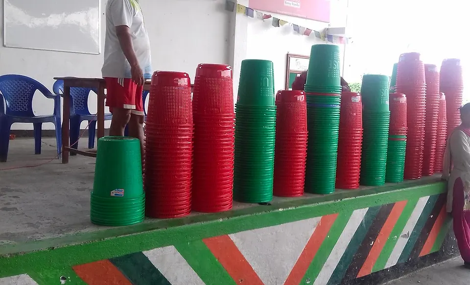 Stacks of green and red buckets ready to be handed out to households for sorting waste